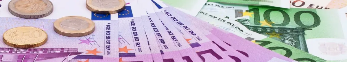 Bunt gemischte Euro-Banknoten und Münzen auf einem Tisch.