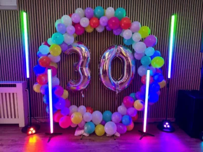 Bunte Ballon-Dekoration mit Figuren "30" und farbigen Lichtstelen.