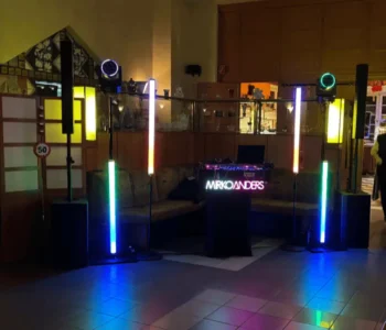 Bunte Lichtinstallation mit Lautsprechern und DJ-Pult in einem Veranstaltungsraum.