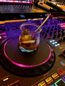 Dessert auf einem DJ-Deck mit bunten Lichtern.