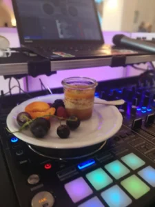 Dessert mit Fruchtstücken und einer Tasse auf einem DJ-Pult mit bunten Tasten. Photo by DJ Mirko Anders