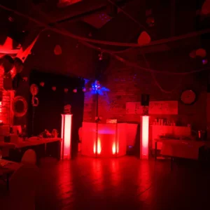 Dunkler Raum mit rotem Licht, Barbereich und dekorativen Elementen. Photo by DJ Mirko Anders