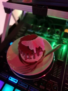 Ein Kirschkuchen mit Sahne auf einem Teller, neben einem DJ-Controller. Photo by DJ Mirko Anders