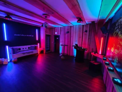 Ein moderner Raum mit bunten Lichtern in Blau und Magenta, Holzverkleidung und Geräten. Photo by DJ Mirko Anders