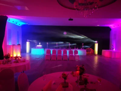Eleganter Veranstaltungsraum mit bunten Lichtern und festlich gedeckten Tischen. Photo by DJ Mirko Anders