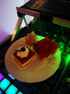 Teller mit zwei Desserts: Käsekuchen und Rote-Gelee-Schnitten, dekoriert mit Sahne. Photo by DJ Mirko Anders