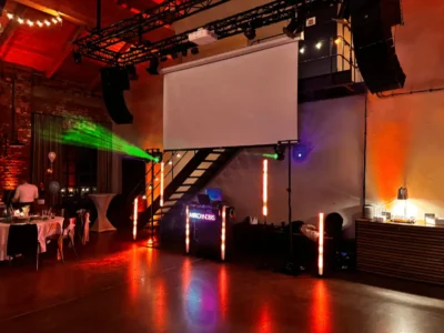Veranstaltungsraum mit Lichtinstallationen und Projektor an der Wand.