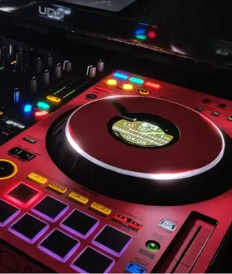 DJ Mirko Anders – Hochzeits-DJ Controller DJ-Pult mit bunten Lichtern, Plattenspieler und elektronischen Steuerungen.